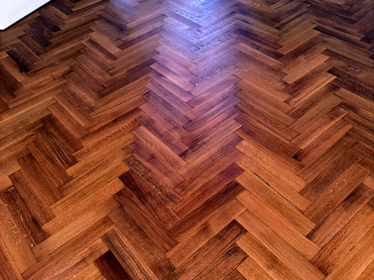 Renoviertes Fischgratparkett mit warmer Holzfarbe